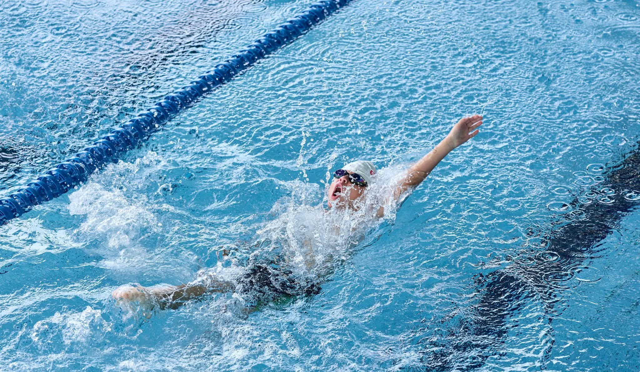 Swimmer racing backstroke in the STAGE 50m pool